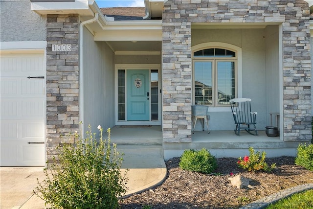 doorway to property featuring a garage and a porch