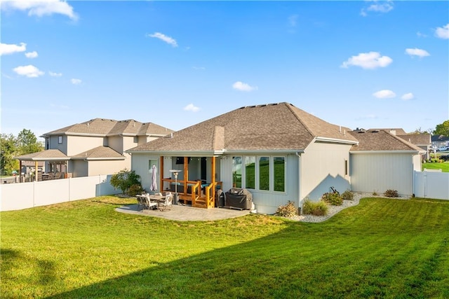 back of house with a yard and a patio