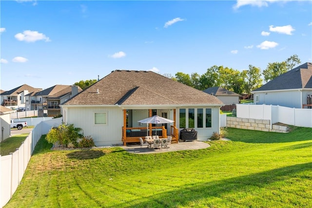 rear view of house featuring a yard and a patio