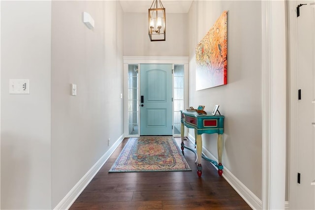 foyer with dark hardwood / wood-style flooring and a notable chandelier