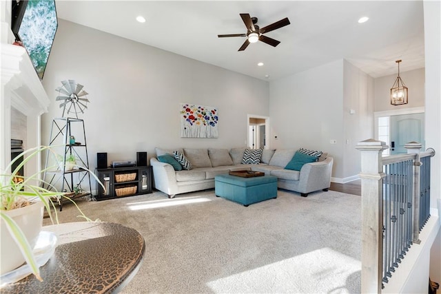 living room featuring a towering ceiling, ceiling fan with notable chandelier, and carpet flooring