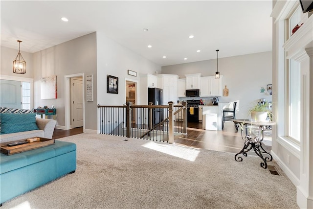 carpeted living room featuring a towering ceiling