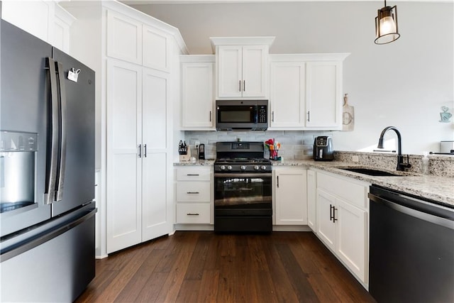 kitchen featuring sink, white cabinets, light stone counters, and black appliances