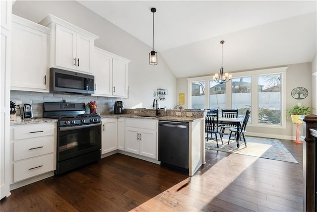 kitchen featuring black gas range oven, dishwashing machine, decorative light fixtures, and white cabinets