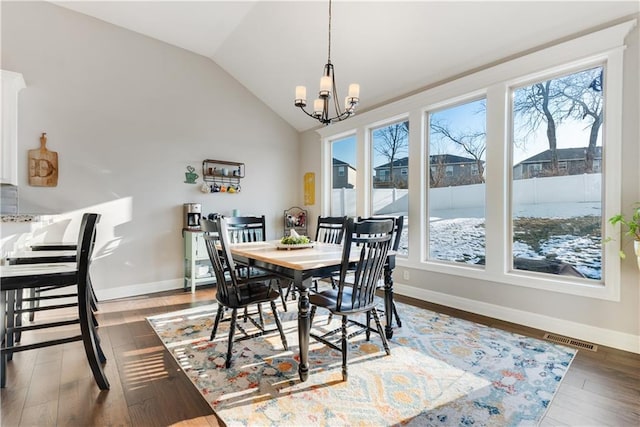 dining room with a notable chandelier, dark hardwood / wood-style flooring, vaulted ceiling, and a wealth of natural light