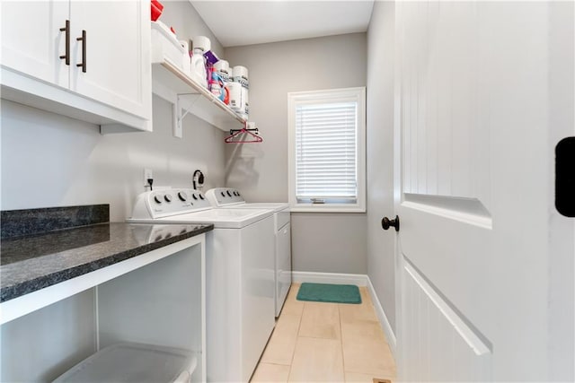 washroom with light tile patterned floors, cabinets, and washing machine and clothes dryer