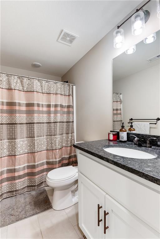 bathroom with tile patterned flooring, vanity, and toilet