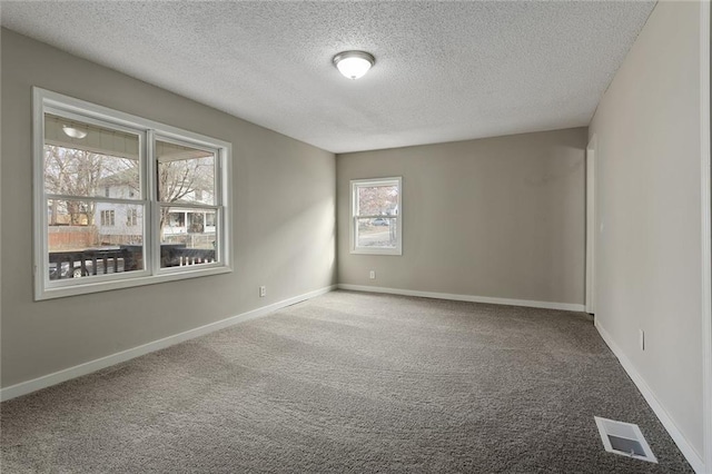 unfurnished room featuring a textured ceiling and carpet floors