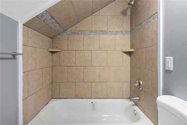 bathroom featuring toilet and tiled shower / bath combo