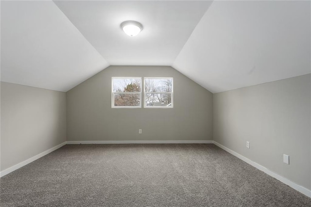 additional living space featuring lofted ceiling and carpet