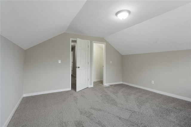 bonus room featuring lofted ceiling and light carpet