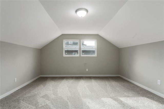 additional living space with vaulted ceiling and carpet floors