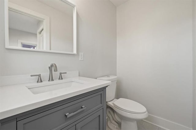 bathroom with toilet, tile patterned floors, and vanity