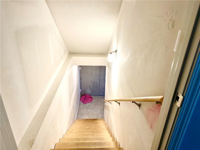 staircase with a textured ceiling