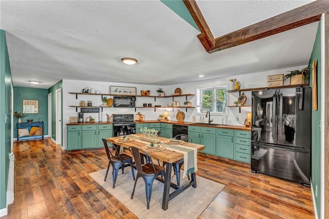 kitchen with sink, a textured ceiling, black appliances, and dark hardwood / wood-style floors