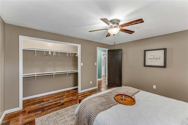 bedroom featuring ceiling fan, dark hardwood / wood-style flooring, and a closet