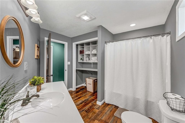 bathroom featuring toilet, vanity, and hardwood / wood-style floors