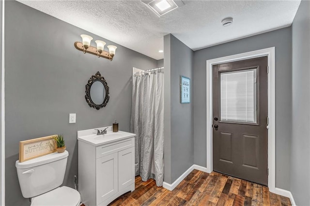 bathroom featuring a textured ceiling, a shower with shower curtain, hardwood / wood-style floors, toilet, and vanity