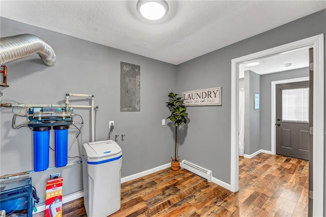 clothes washing area featuring hookup for an electric dryer, washer hookup, dark hardwood / wood-style floors, a baseboard heating unit, and a textured ceiling