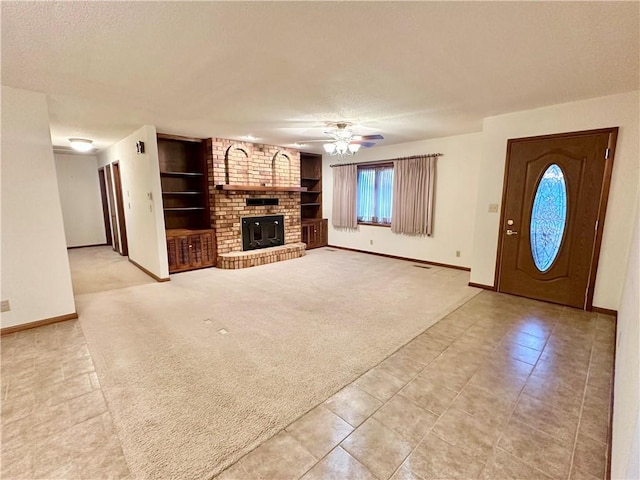 unfurnished living room featuring ceiling fan, light colored carpet, a fireplace, and built in shelves