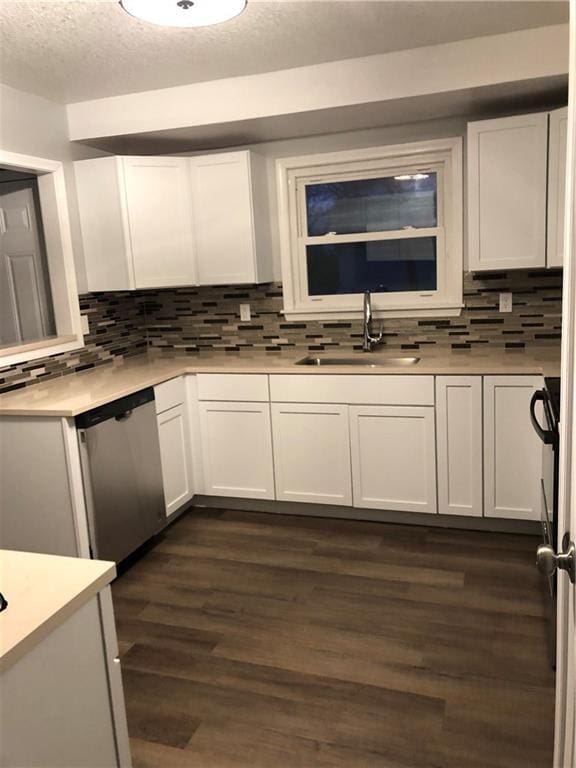 kitchen featuring sink, dark hardwood / wood-style flooring, white cabinets, and stainless steel dishwasher