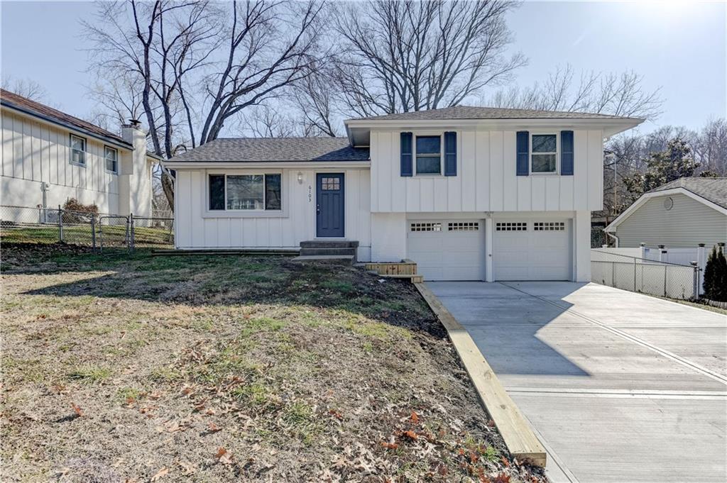 tri-level home with a garage and a front lawn