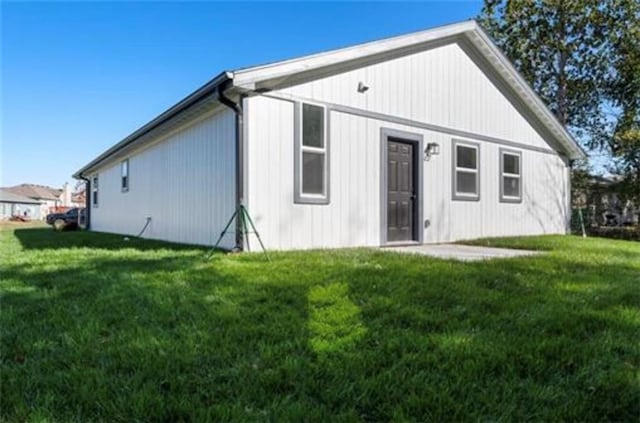 rear view of property featuring a lawn