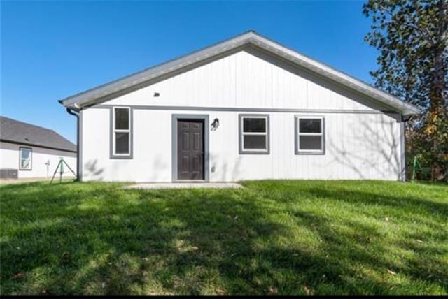 rear view of house featuring a lawn