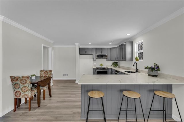 kitchen with stainless steel appliances, sink, gray cabinets, kitchen peninsula, and crown molding