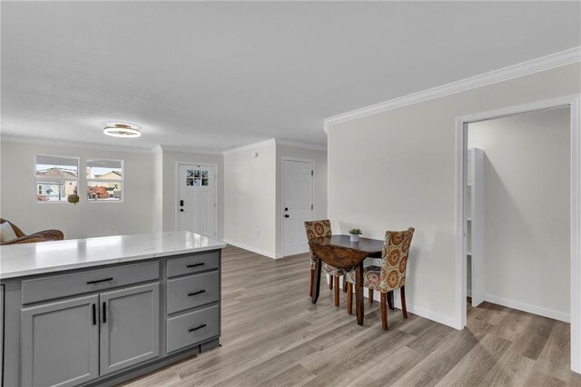 kitchen with crown molding, gray cabinets, and light hardwood / wood-style floors