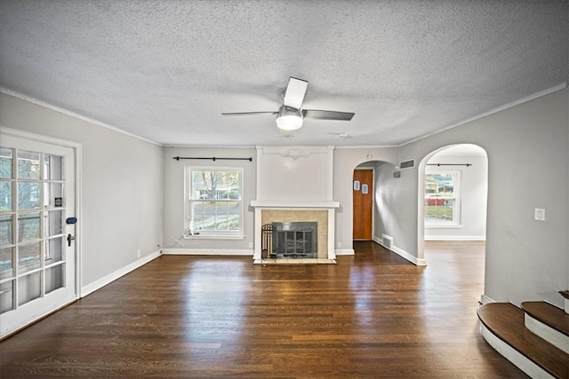 unfurnished living room featuring a textured ceiling, ceiling fan, crown molding, and dark hardwood / wood-style floors