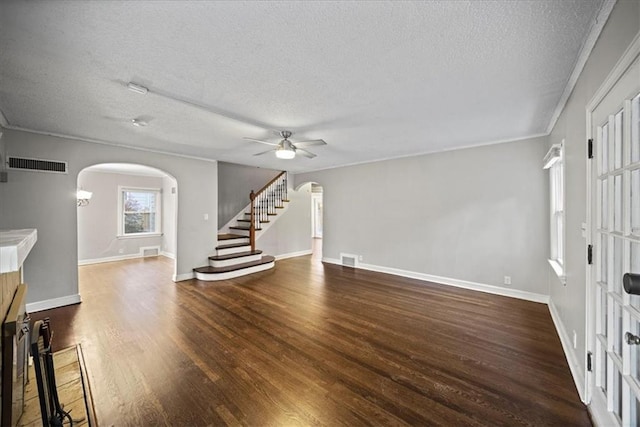 unfurnished living room with ceiling fan, dark hardwood / wood-style floors, and a textured ceiling