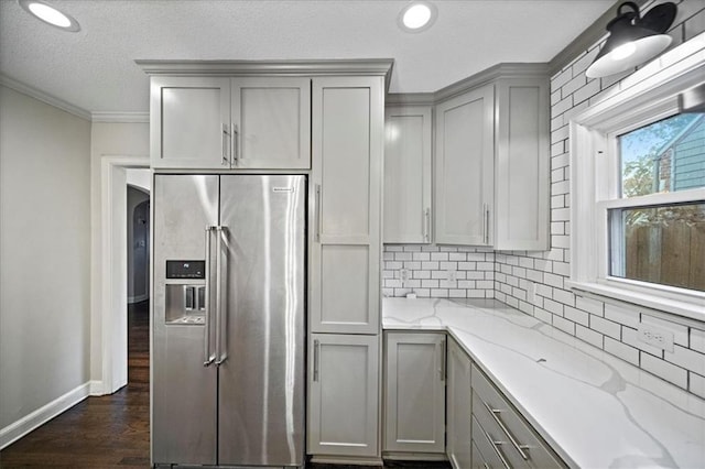 kitchen featuring gray cabinetry, ornamental molding, light stone counters, dark hardwood / wood-style floors, and high end refrigerator