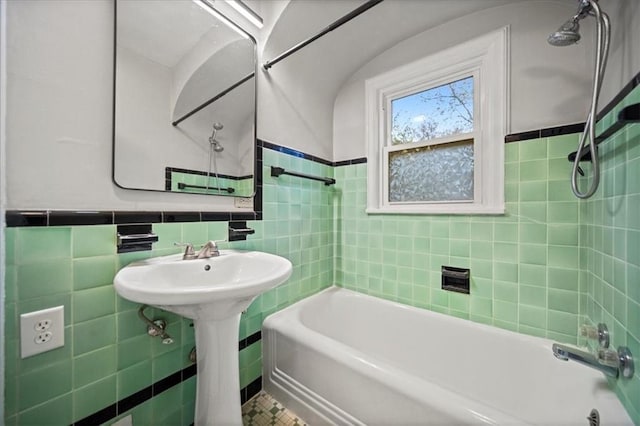 bathroom with tile walls and tiled shower / bath