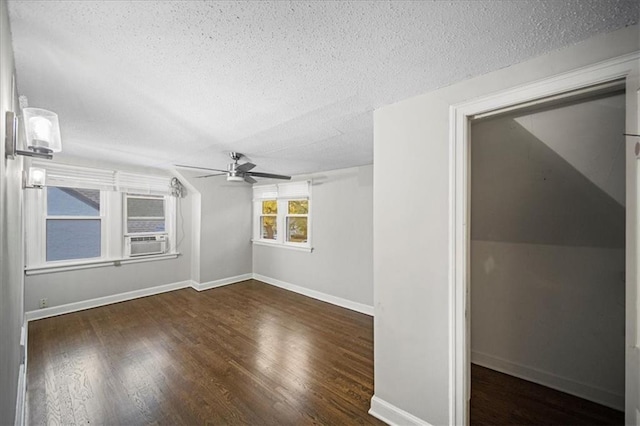 unfurnished room with ceiling fan, dark wood-type flooring, cooling unit, and a textured ceiling