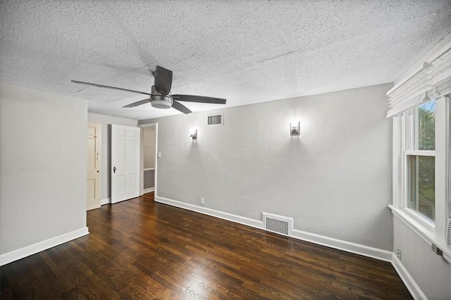 empty room featuring dark hardwood / wood-style flooring, a textured ceiling, and ceiling fan