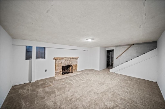 basement with carpet floors and a stone fireplace