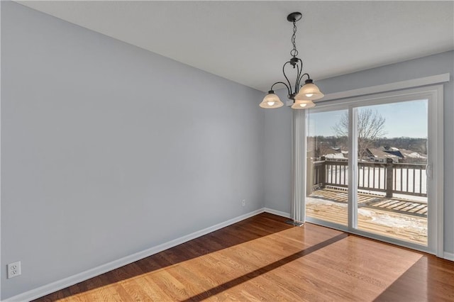 unfurnished dining area featuring hardwood / wood-style floors and a chandelier