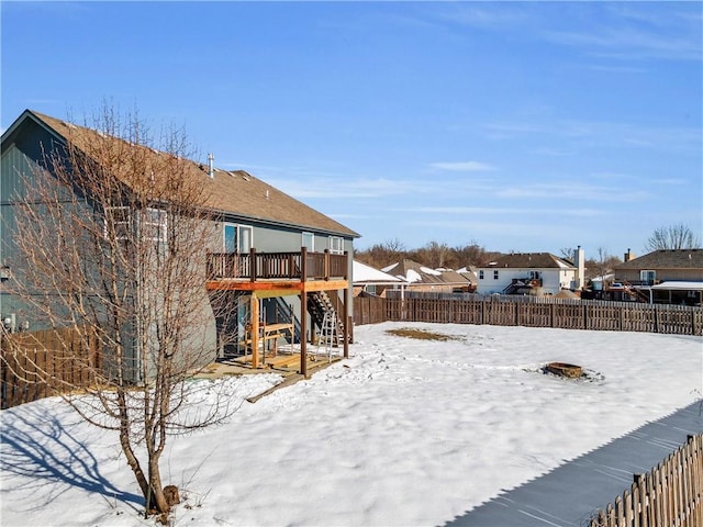 snowy yard featuring a wooden deck