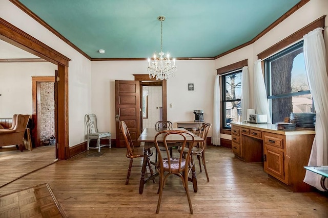 dining room featuring ornamental molding, wood-type flooring, and a chandelier