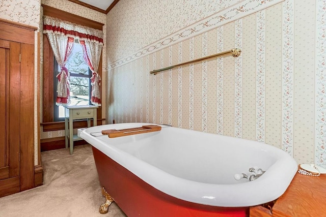 bathroom with a tub to relax in and crown molding