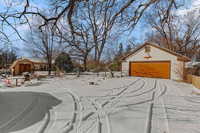 yard layered in snow featuring a garage