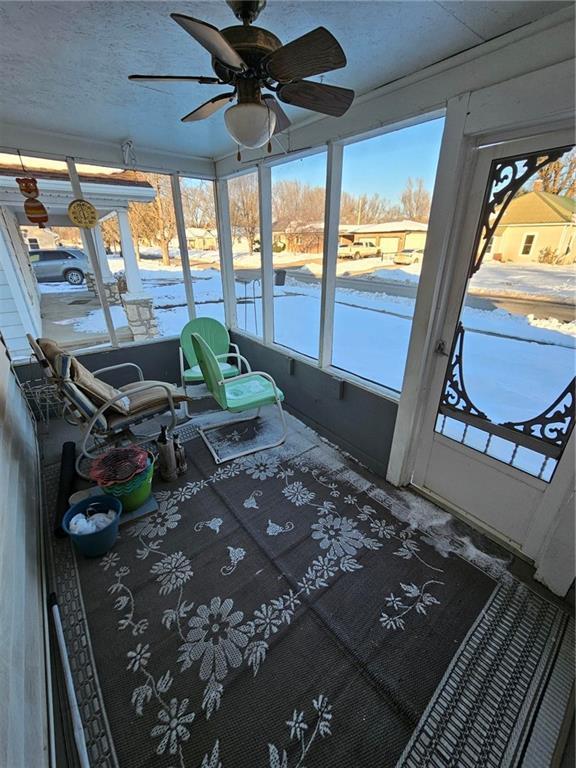 unfurnished sunroom with ceiling fan