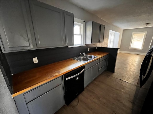 kitchen with wooden counters, gray cabinets, dishwasher, and sink