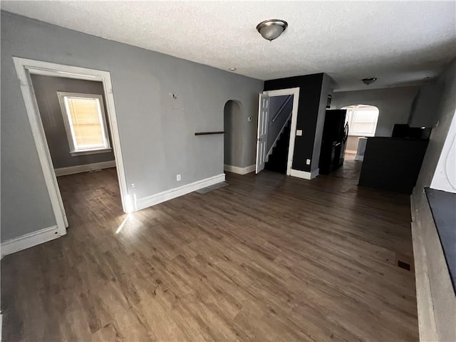 interior space featuring a textured ceiling and dark hardwood / wood-style floors