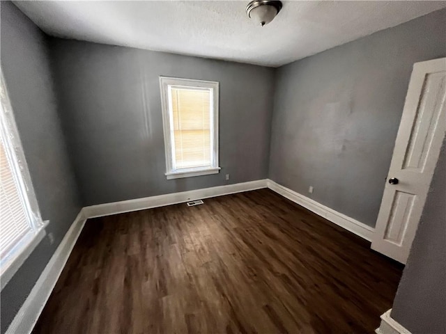 spare room with dark hardwood / wood-style flooring