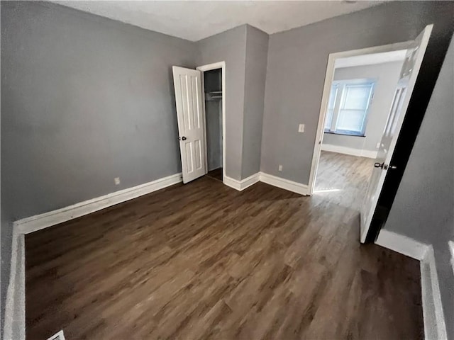 unfurnished bedroom with dark wood-type flooring