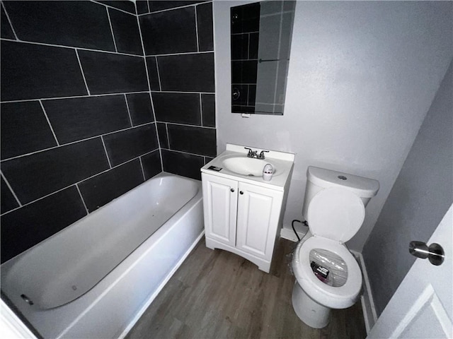 full bathroom featuring toilet, tiled shower / bath combo, vanity, and hardwood / wood-style floors