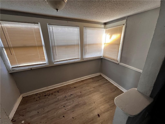 spare room with a textured ceiling and hardwood / wood-style flooring