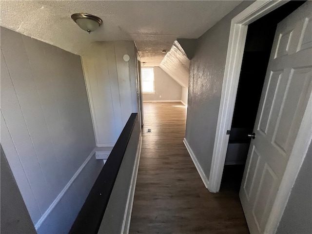 hallway with dark wood-type flooring and a textured ceiling